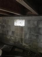 Open crawlspace vent with leaking cinderblock wall.