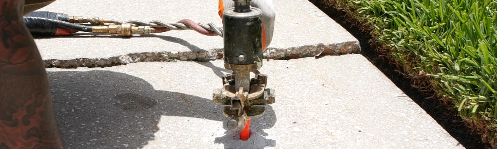 Crew injecting poly into a sidewalk.