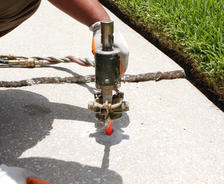 Crew injecting poly into a sidewalk.