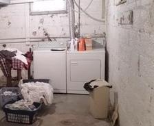 Laundry in basement with damp floors.