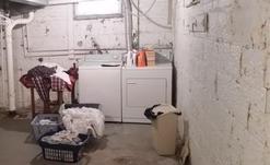 Laundry in basement with damp floors.