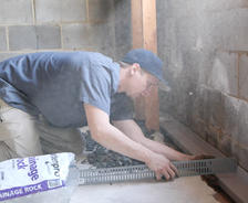Crew installing basement gutter and drainage rock.