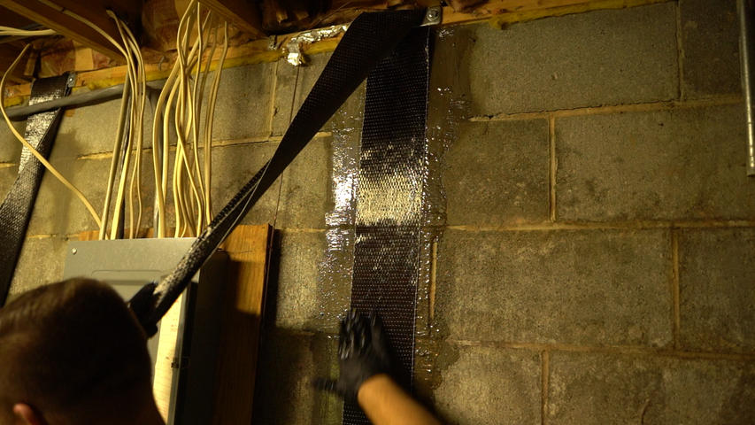 Crew installing carbon fiber basement wall repair