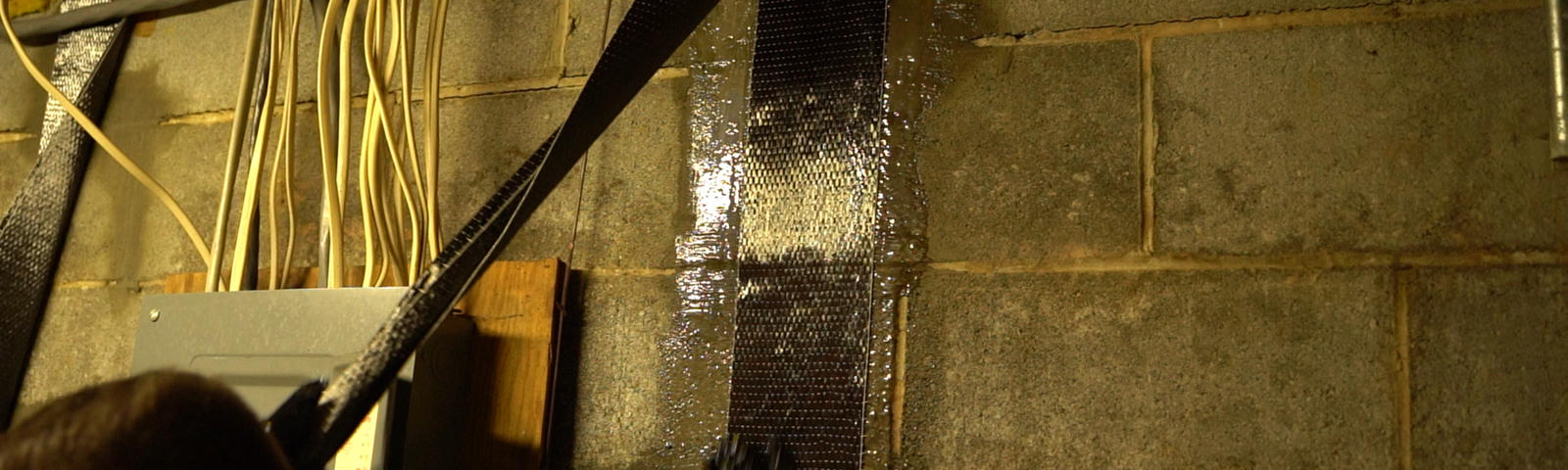 Crew installing carbon fiber basement wall repair