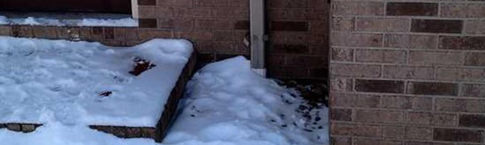 Snow covering downspout and drain.