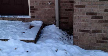 Snow covering downspout and drain.