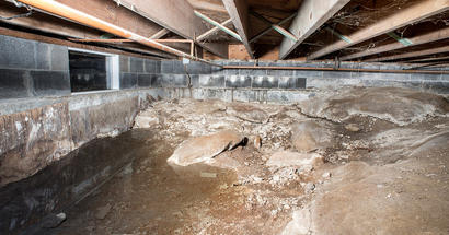 Standing water in a dirty, humid crawlspace.