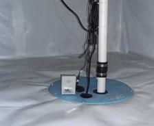 Close-up of vapor barrier and sump pump in crawlspace.