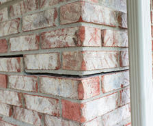 Close-up of a brick wall with visible cracking and separation between the bricks.