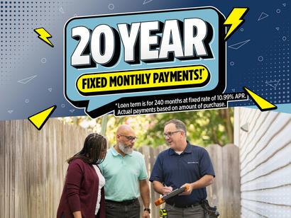 A couple speaks with a worker outdoors under a sign reading “20 Year Fixed Monthly Payments!”