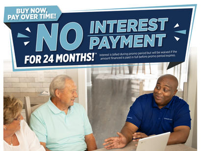 Three people discussing finances at a table, with a sign reading "No interest payment for 24 months.
