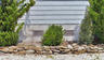 SmartVent flood vents installed on a home with bushes and rocks