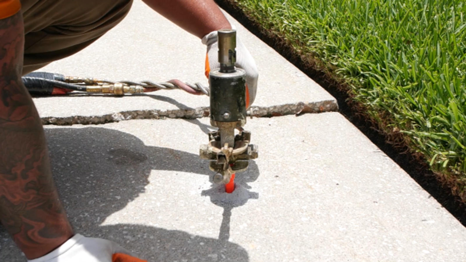 Technician injecting poly into the sidewalk.