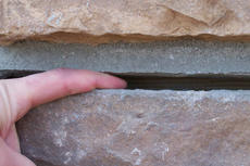 Hand in between horizontal foundation crack.