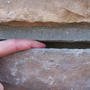 Hand in between horizontal foundation crack.