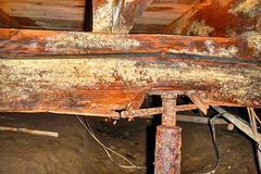 Sagging and wood rot floor joist in crawlspace.