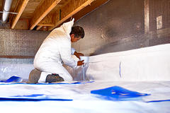 Crew installing crawlspace insulation tape.