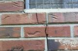 The exterior brick wall is cracking up to the window seal.