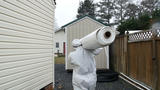 Crew carrying vapor barrier outside of the job site.