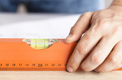 Close-up of hand measuring floor.
