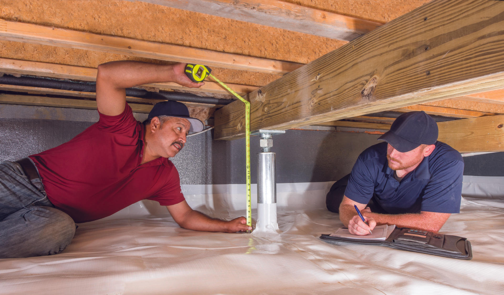 Production crew measuring IntelliJack in crawlspace.