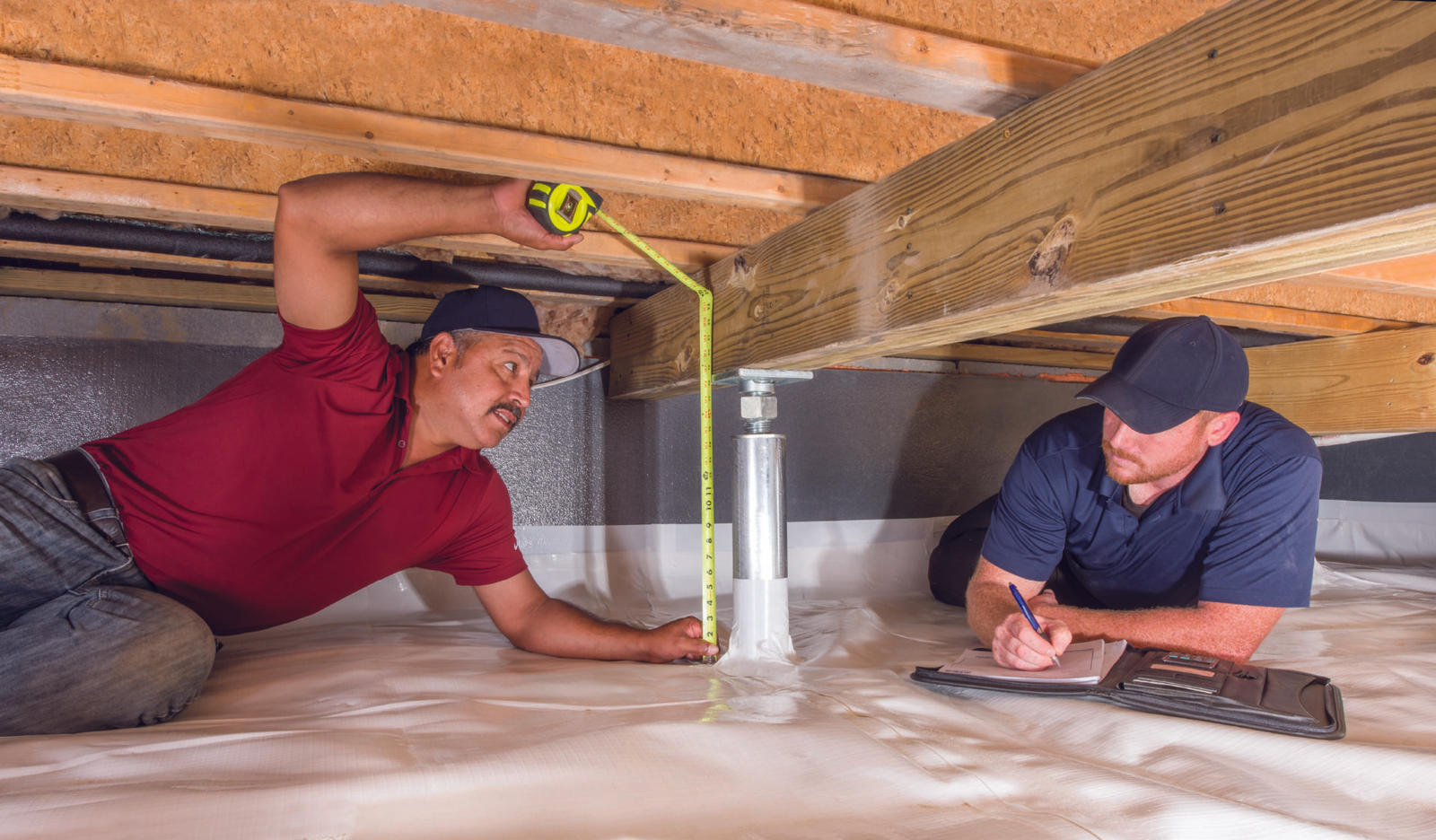 Production crew measuring IntelliJack in crawlspace.