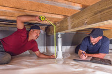 Production crew measuring IntelliJack in crawlspace.