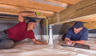Production crew measuring IntelliJack in crawlspace.