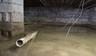Flooded crawl space with murky water and a partially submerged pipe; exposed support beams above.