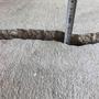 Large crack in concrete close up with tape measure