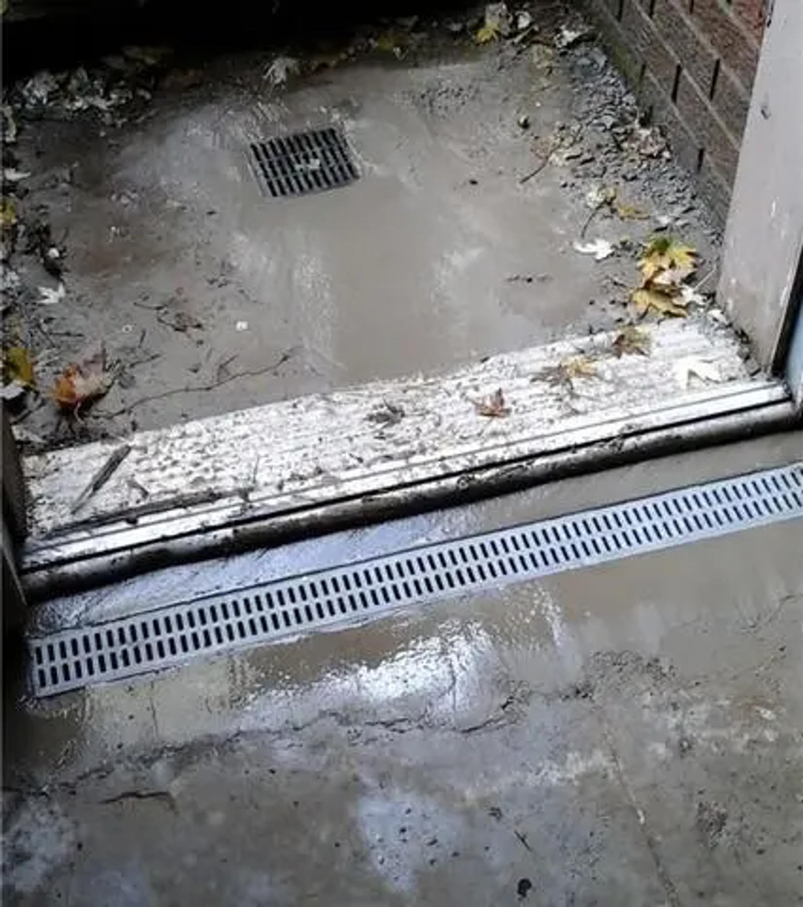 Grated Drainage Pipe installed at the threshold of a basement