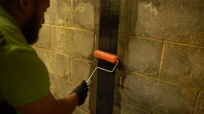 Crew installing epoxy on carbon fiber wall repair