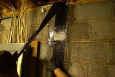 Crew smoothing out carbon fiber basement wall repair