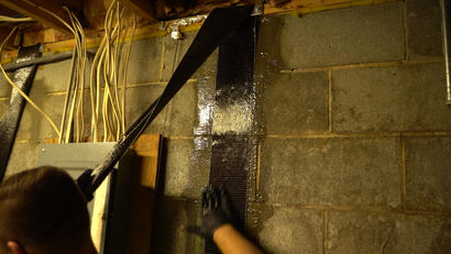 Crew smoothing out carbon fiber basement wall repair