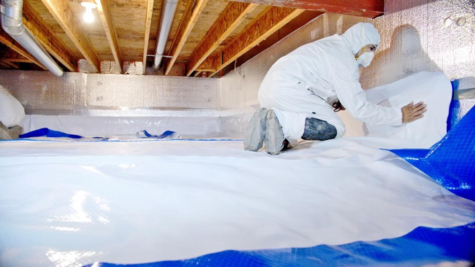 Groundworks expert encapsulates a crawl space in safety gear.