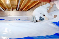 Groundworks expert encapsulates a crawl space in safety gear.