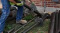 Crew picking up helical pier outside of home
