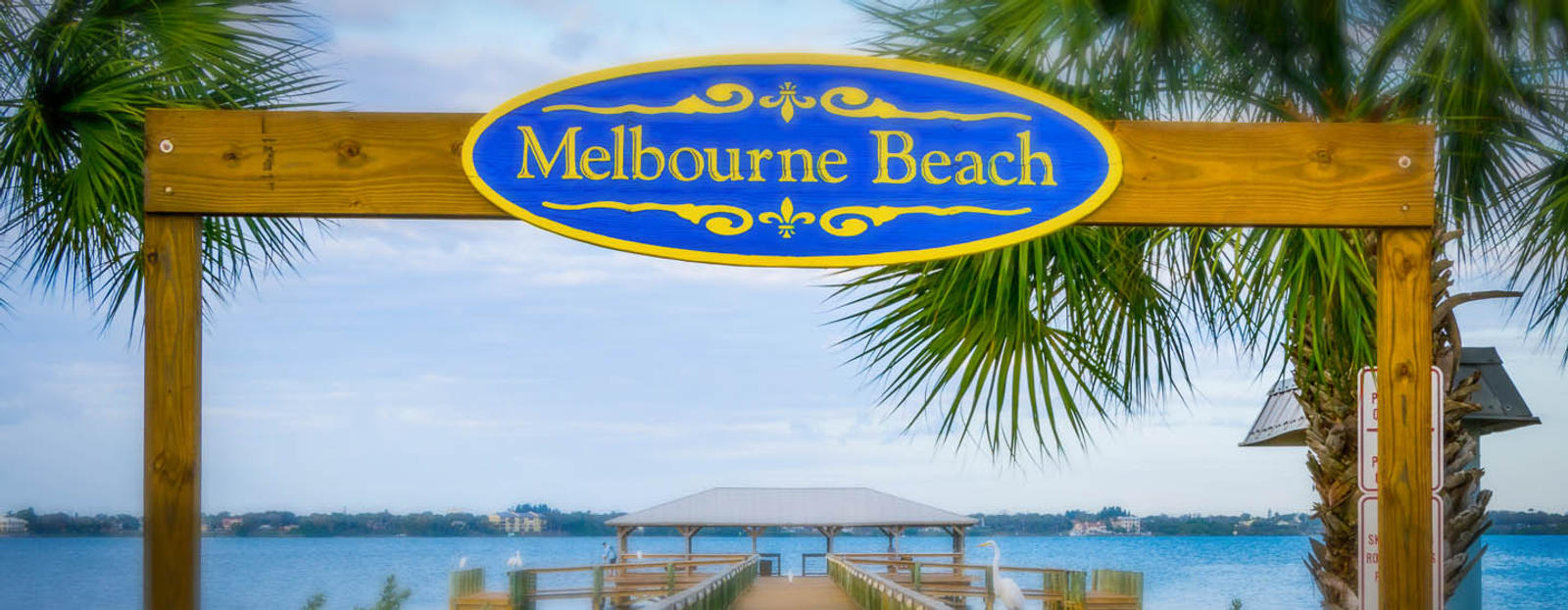 Melbourne Beach sign next to water