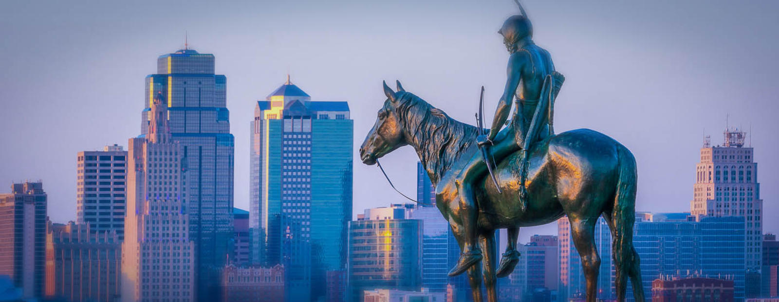 Monument of man on horse with Kansas City skyline