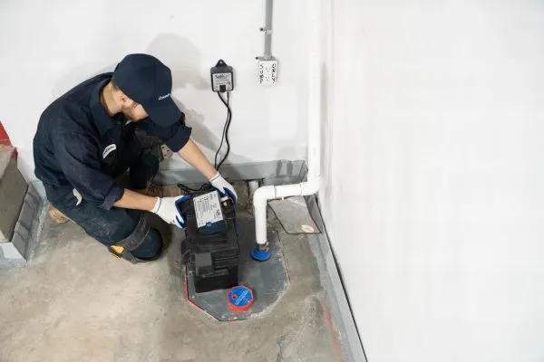 Groundworks worker installing basement sump pump