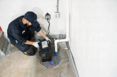 Groundworks worker installing basement sump pump
