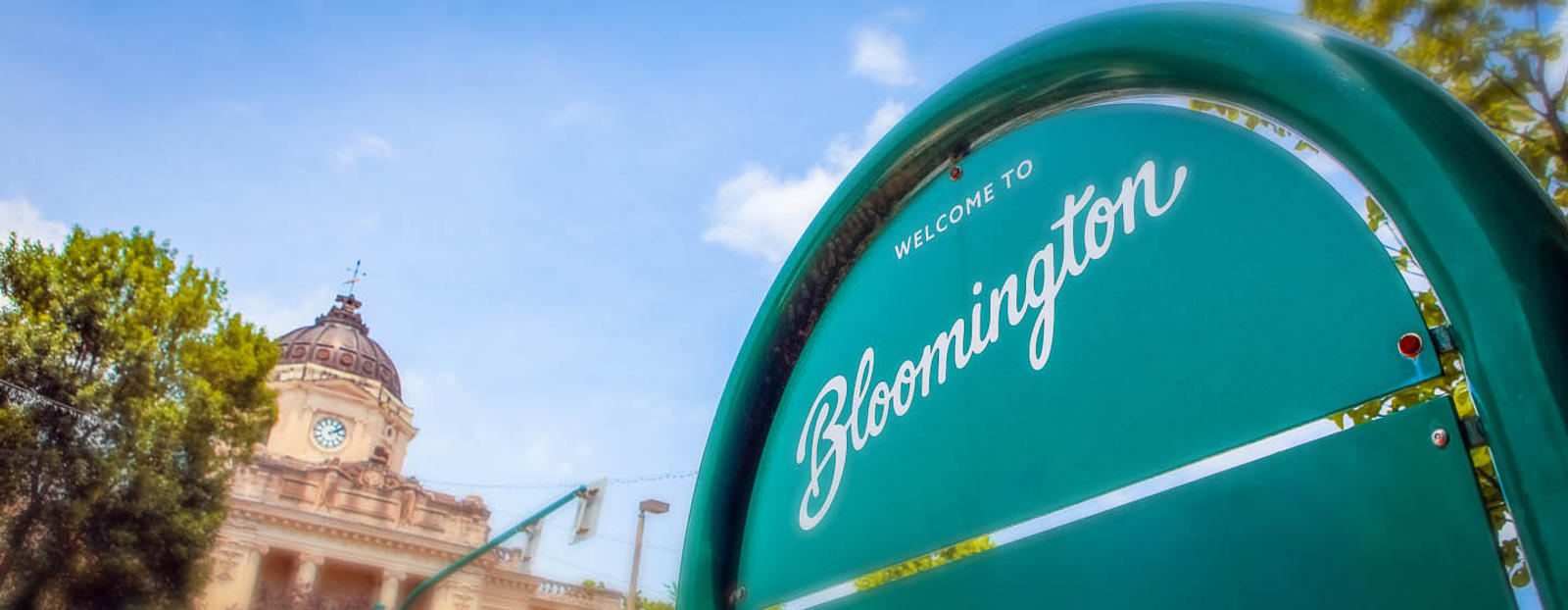Welcome to Bloomington, Indiana sign with clock tower in backround