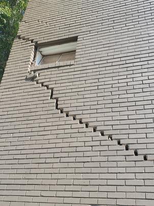 Stairstep crack in large brick wall on home