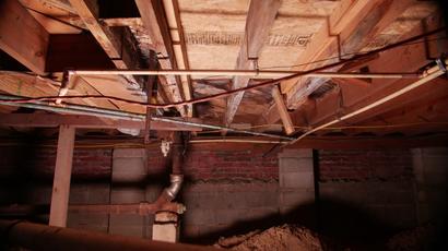 rusty pipes in moldy crawl space