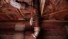 Rusty pipes with rotting wet and moldy crawl space wood