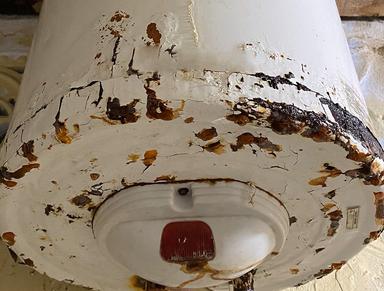 Closeup of the bottom of a rusty water heater