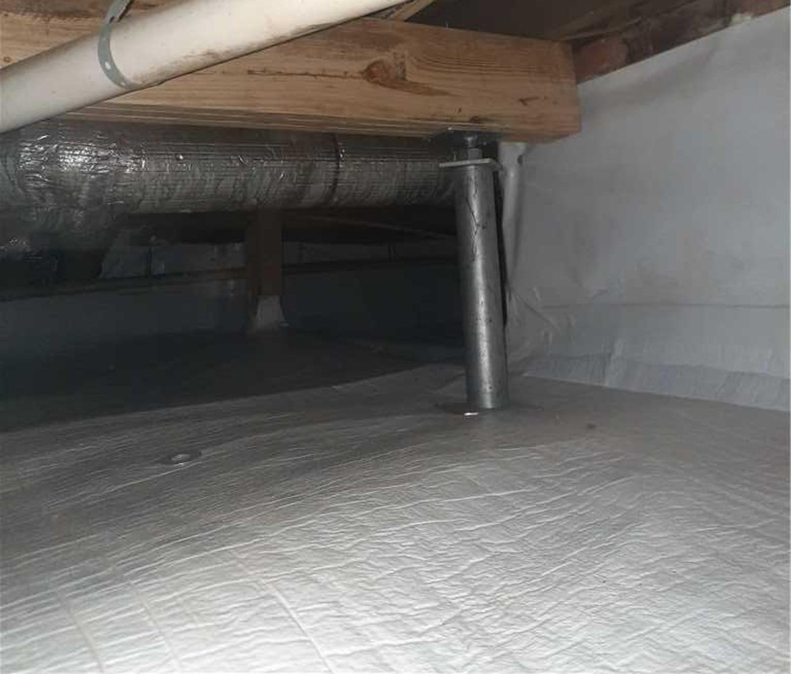 Crawl space with insulated ductwork and a metal support rod under a wooden beam.
