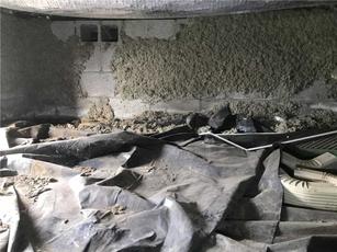 Crawl space with exposed concrete walls and plastic sheeting on the ground.