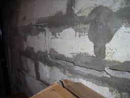 Close up of cracking and bowing concrete basement wall