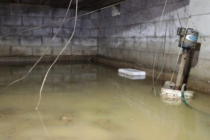 flooded crawl space with bucket and wires